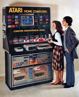 Computer Demo Center Retro image of young couple standing in front of a large Atari home computer