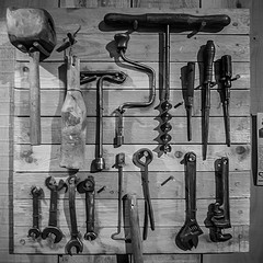 Wall of tools Black-and-white photo of tools hanging on a wall