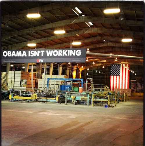 Romney Rebuttal Sign reading Obama Isn't Working hangs in front of American flag in empty factory