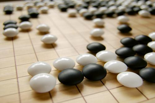 Game Pieces Black and white game pieces on a wooden board