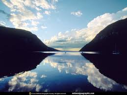 Reflection A mountain range reflected in a lake so that the mountains and sky looks duplicated in the lake