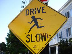 Drive Slow Street Sign with "ly" marked in after "Slow"
